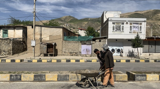 Des employés municipaux afghans nettoient le site d'une bombe collante qui a explosé à côté d'un convoi de sécurité à Fayzabad, dans la province de Badakhshan, le 8 mai 2024.