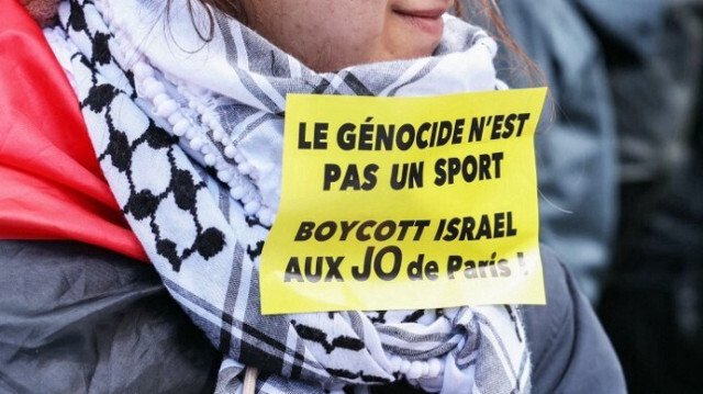 Un manifestant porte un autocollant avec l'inscription "le génocide n'est pas un sport, boycott d'Israël aux Jeux olympiques de Paris" lors d'une manifestation "contre le racisme, contre l'islamophobie", à Paris le 21 avril 2024. 