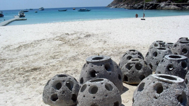 Des "boules de récif" en béton destinées à créer des récifs coralliens artificiels, posées sur le sable de l'île de Raja, au large de la pointe sud de l'île de Phuket, en Thaïlande. 