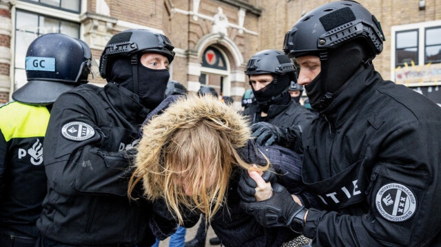 Des policiers néerlandais arrêtent violemment une étudiante lors d'une manifestation appelant l'université à rompre tous les liens avec Israël en raison de son offensive militaire meurtrière à Gaza, à l'Université d'Amsterdam (UvA), le 8 mai 2024.