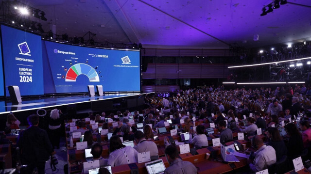 Des journalistes dans l'hémicycle du Parlement européen à Bruxelles alors que les premières projections de la future composition de l'assemblée apparaissent sur un écran après l'annonce des résultats de l'élection du Parlement européen, en Belgique, le 9 juin 2024.