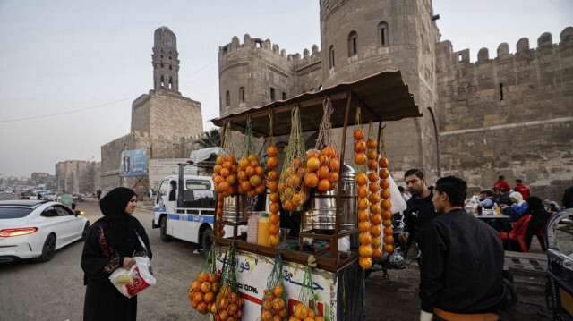 Un vendeur vend du jus de fruit pour permettre aux gens de rompre leur jeûne pendant le mois sacré du Ramadan, au coucher du soleil, à l'extérieur de Bab al-Futuh (Porte des Conquêtes), l'une des trois portes médiévales restantes de l'ancienne muraille du Caire construite à la fin du XIe siècle, le 30 mars 2024.