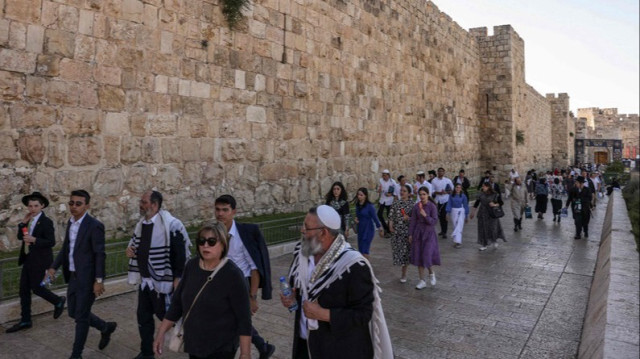 Des colons israéliens marchent devant le complexe de la mosquée Al-Aqsa à Jérusalem-Est pour accomplir des rituels talmudiques pour marquer la fête juive de Shavuot (Pentecôte), le 12 juin 2024.