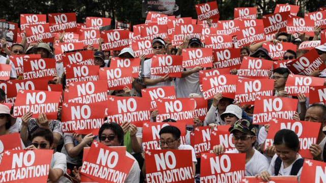 Des manifestants tiennent des pancartes lors d'un rassemblement contre une proposition de loi controversée sur l'extradition à Hong Kong, le 9 juin 2019.