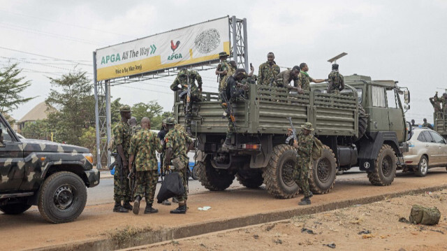 Des officiers armés de l'armée nigériane montent dans un véhicule militaire garé devant la Banque centrale du Nigeria (CBN) à Awka, au Nigeria, le 24 février 2023, avant les élections présidentielles nigérianes prévues pour le 25 février 2023.