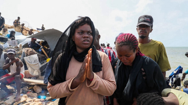 Des migrants africains, bloqués sur le bord de mer à la frontière entre la Libye et la Tunisie à Ras Jedir, restent sur la plage rocheuse le 26 juillet 2023. 