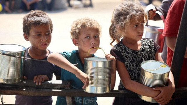 Des enfants attendent que de la nourriture soit distribuée dans un camp de personnes déplacées à l'intérieur de la bande de Gaza, le 11 juin 2024.