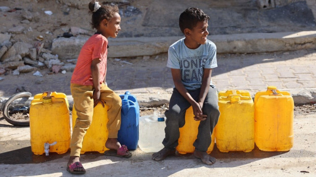 Des enfants palestiniens sont assis sur des conteneurs d'eau dans la ville de Gaza le 10 juin 2024, confrontés à des pénuries d'eau potable.