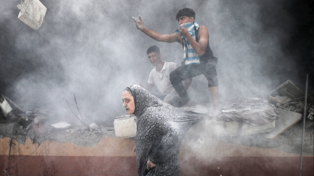 Des civils gazaouis sortant de leur maison tout juste bombardée, le 14 juin 2024.