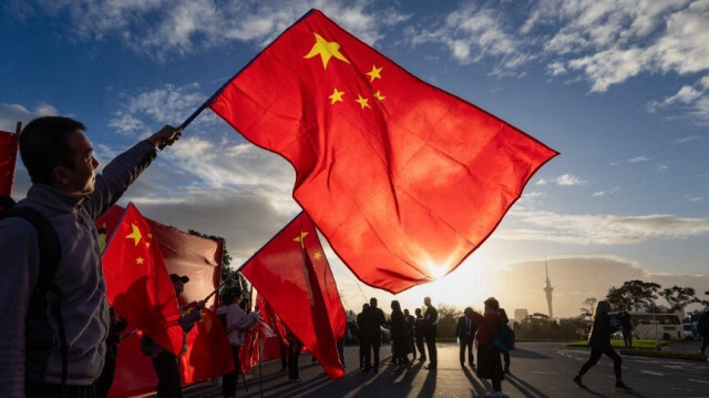 Des partisans du premier ministre chinois Li Qiang agitent des drapeaux nationaux chinois à l'extérieur d'un événement organisé au musée d'Auckland, le 14 juin 2024.