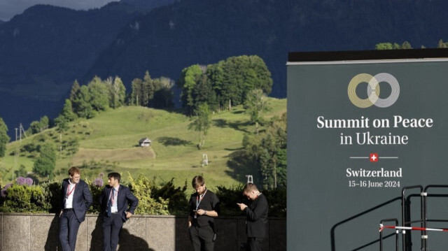 Des membres du personnel se tiennent prêts pendant le sommet sur la paix en Ukraine, près de l'entrée de la station de luxe Burgenstock, près de Lucerne, le 15 juin 2024. 