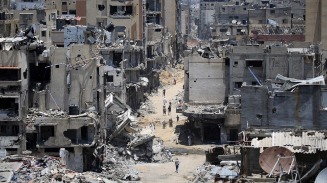 Des Palestiniens marchent dans une rue dévastée de Khan Yunis, dans le sud de la bande de Gaza, le 14 juin 2024.