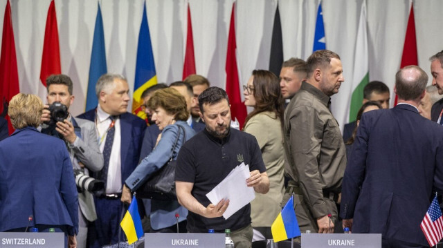 Le président ukrainien Volodymyr Zelensky consulte des documents lors d'une session plénière du sommet sur la paix en Ukraine, dans la luxueuse station de Burgenstock, près de Lucerne, le 16 juin 2024.