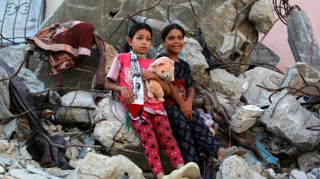 Des filles palestiniennes sur les décombres d'un bâtiment détruit alors qu'elles célèbrent l'Aïd al-Adha à Khan Yunis, dans le sud de la bande de Gaza, le 16 juin 2024.