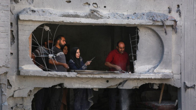 Des Palestiniens déblaient les décombres d'un immeuble d'habitation endommagé par des frappes israéliennes dans le camp de réfugiés d'al-Bureij, dans le centre de la bande de Gaza, le 18 juin 2024.