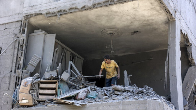 Un jeune cherche des objets récupérables dans un appartement endommagé par les bombardements israéliens dans le camp de réfugiés d'al-Shati à Gaza City, le 22 juin 2024.