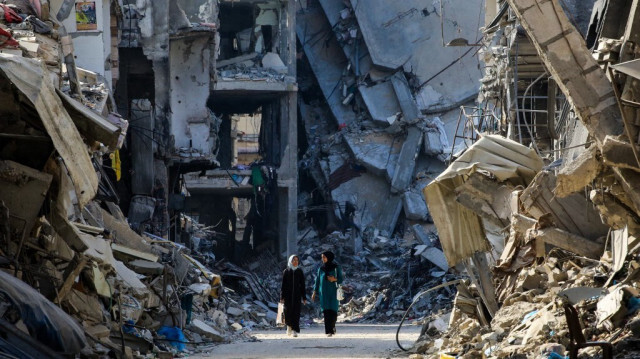 Des femmes palestiniennes passent devant des bâtiments détruits à Khan Yunis, le 20 juin 2024.