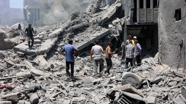 Un sauveteur se tenant sur les décombres d'un bâtiment détruit lors d'un bombardement israélien au camp de réfugiés d'al-Shati dans la ville de Gaza le 22 juin 2024, dans le cadre du conflit actuel entre Israël et le groupe militant palestinien Hamas.
