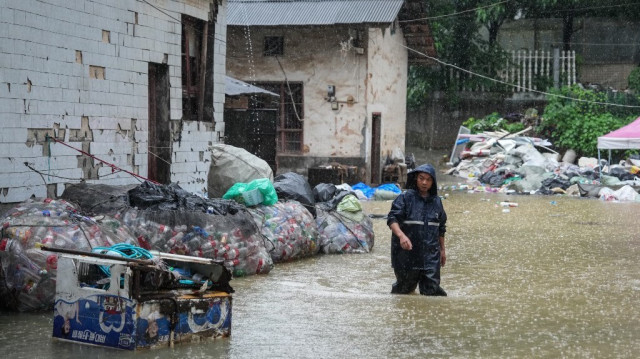 Un homme patauge dans les eaux de crue suite à de fortes pluies à Changsha, dans la province du Hunan en Chine centrale, le 24 juin 2024.