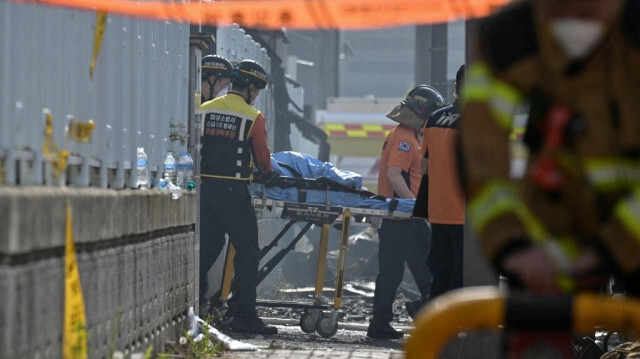 Le personnel d'urgence transporte le corps d'une victime sur les lieux d'un incendie dans une usine de batteries au lithium appartenant au fabricant de batteries sud-coréen Aricell à Hwaseong, le 24 juin 2024.