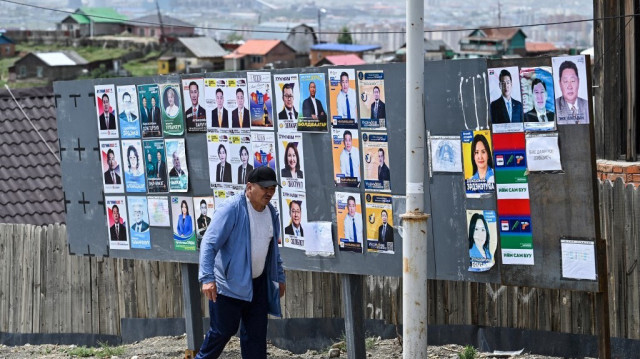 Un homme passe devant les affiches des candidats aux élections législatives à Ulaanbaatar le 25 juin 2024, avant les élections du 28 juin.