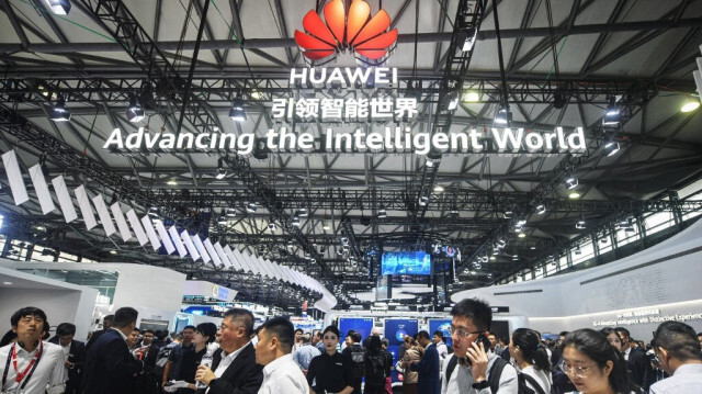 Des gens passent devant le stand de Huawei au Mobile World Congress (MWC) à Shanghai, le 26 juin 2024.