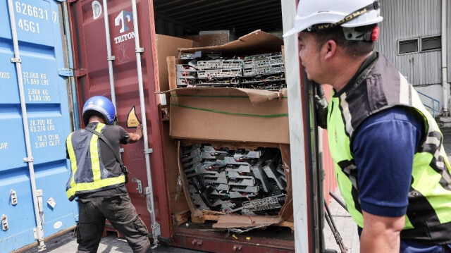 Des fonctionnaires malaisiens ouvrent un conteneur saisi contenant des déchets électroniques à Port Klang, dans la banlieue de Kuala Lumpur en Malaisie, le 26 juin 2024.