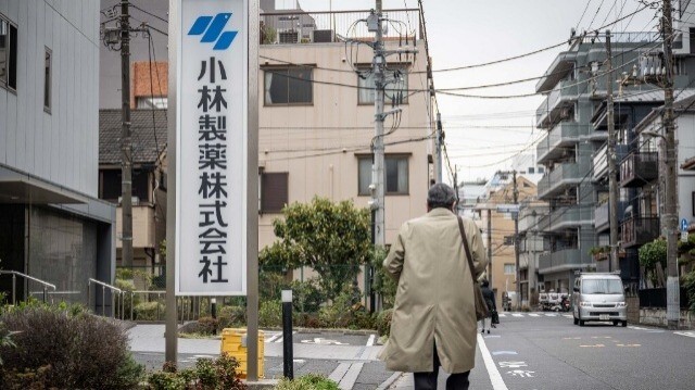 Un homme passant devant les panneaux de Kobayashi Pharmaceutical à l'extérieur des bureaux de la société à Tokyo.