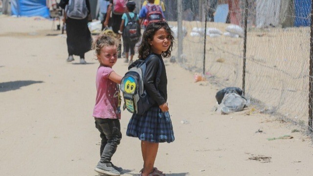Des enfants palestiniens déplacés regardent les gens évacuer la zone de Mawassi à la périphérie du sud-ouest de Khan Younes dans le sud de la bande de Gaza le 28 juin 2024, dans le cadre du conflit actuel entre Israël et le groupe militant du Hamas.