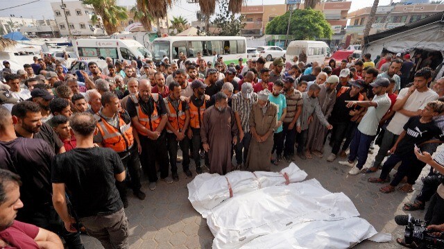 Des collègues et des personnes en deuil priant devant les corps de quatre volontaires de la défense civile, tués lors du bombardement israélien du camp de réfugiés de Nuseirat, lors de leurs funérailles à l'hôpital des Martyrs d'Aqsa à Deir el-Balah, le 28 juin 2024, suite aux bombardements israéliens dans le centre de la bande de Gaza, dans le cadre des combats entre Israël et le groupe militant palestinien Hamas.