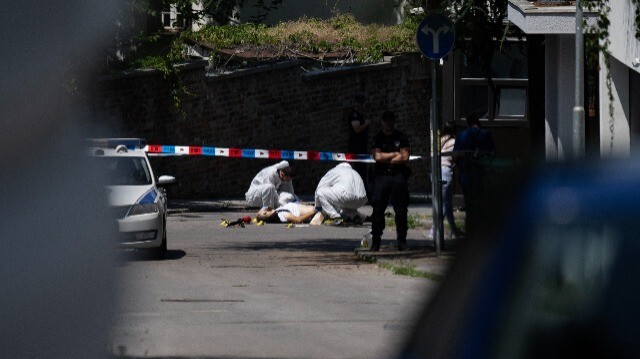 Des agents de la police scientifique inspectant un corps gisant sur la route à côté de l'ambassade d'Israël à Belgrade, le 29 juin 2024. Un homme armé d'une arbalète a tiré et blessé un policier qui gardait l'ambassade d'Israël, avant d'être mortellement abattu en retour par ce dernier, ont indiqué des responsables.