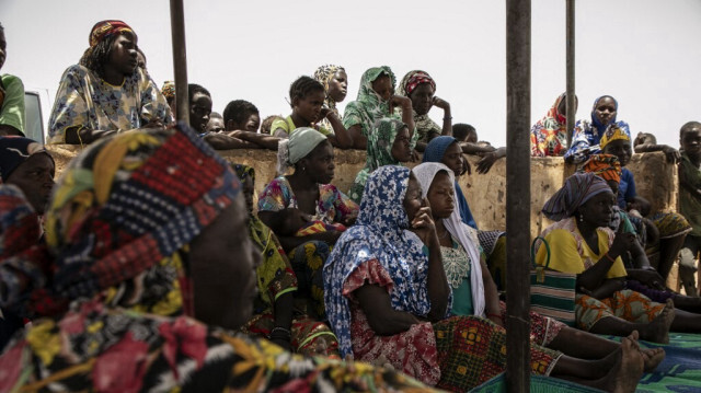Des femmes déplacées se rassemblent à l'ombre dans le camp de déplacés de Torodi à Dori, le 30 mai 2024. 