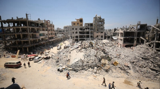 Des Palestiniens marchent parmi les décombres des bâtiments détruits à Jabalia dans la Bande de Gaza.
