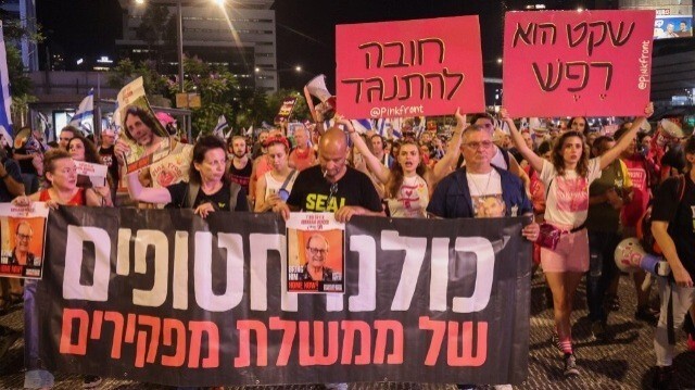 Des parents et des sympathisants d'Israéliens retenus en otage par des militants palestiniens à Gaza depuis les attaques d'octobre brandissent des drapeaux et des pancartes lors d'une manifestation réclamant leur libération dans le centre de Tel-Aviv, le 29 juin 2024.