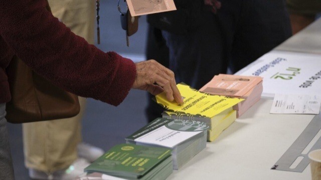 Une personne recueille des bulletins de vote dans un bureau de vote à l'intérieur de la mairie de Koutio à Dumbea dans la deuxième circonscription du territoire français du Pacifique de Nouvelle-Calédonie, le 30 juin 2024.