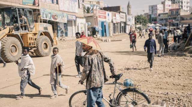 Un homme portant un chapeau parapluie avec le drapeau de la région du Tigré traverse à vélo une route nouvellement construite à Mekele, le 24 mai 2024. 