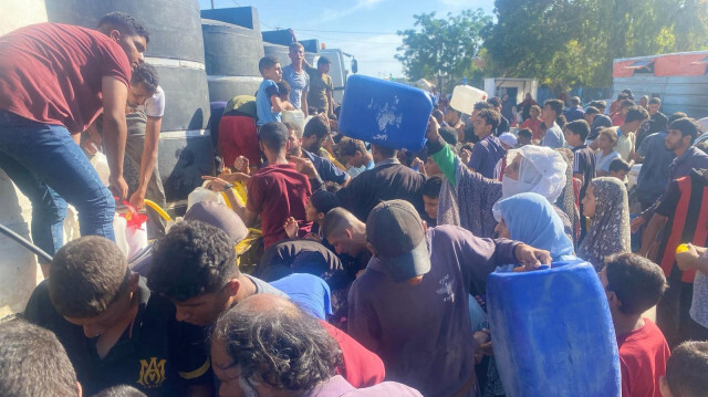 Les familles et les enfants Palestiniens parcourent de longues distances dans la chaleur pour aller chercher de l'eau dans la Bande de Gaza, le 04 juin 2024.