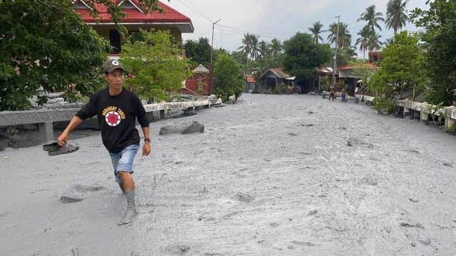 Un habitant pataugeant dans un lahar provenant de l'éruption du volcan du mont Kanlaon le long d'une route dans le village de Biaknabato dans la municipalité de La Castellana, dans la province de Negros Occidental au Philippines.