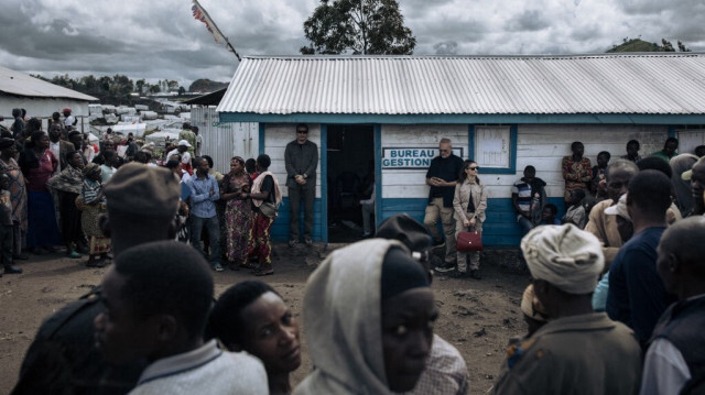 Des personnes déplacées par la guerre se rassemblent pour regarder une délégation de fonctionnaires de l'ONU visitant le camp de déplacés de Bulengo, près d'une ligne de front à la périphérie ouest de Goma, le 17 avril 2024.