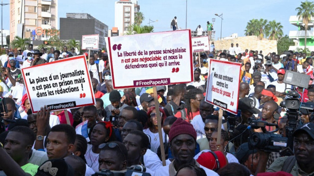 Des journalistes sénégalais tiennent des banderoles et crient des slogans lors de la marche pour la libération de leur collègue Pape Alé Niang à Dakar le 18 novembre 2022, arrêté pour avoir critiqué le gouvernement.