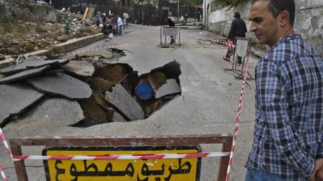 Un homme se tient à côté d'un gouffre creusé par de fortes pluies dans la capitale algérienne Alger, le 8 septembre 2020.