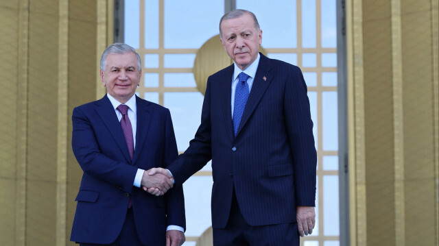 Erdoğan ve Mirziyoyev, merdivenlerde tokalaşarak, gazetecilere poz verdi.