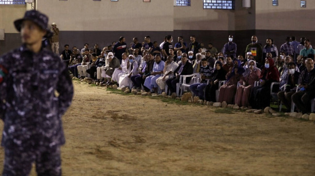 Des personnes regardent la libération de soixante-dix-huit prisonniers arrêtés lors de l'attaque de la ville de Tripoli et actuellement détenus dans l'institution de réforme et de réhabilitation, à Tripoli, le 12 mai 2021.