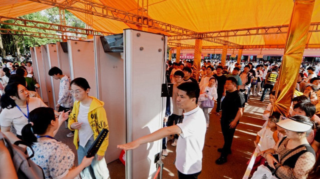 Des étudiants font la queue pour passer un contrôle de sécurité à l'extérieur d'une école le premier jour de l'examen national d'entrée à l'université, connu sous le nom de "Gaokao ", à Bozhou, dans la province d'Anhui (centre de la Chine), le 7 juin 2024.