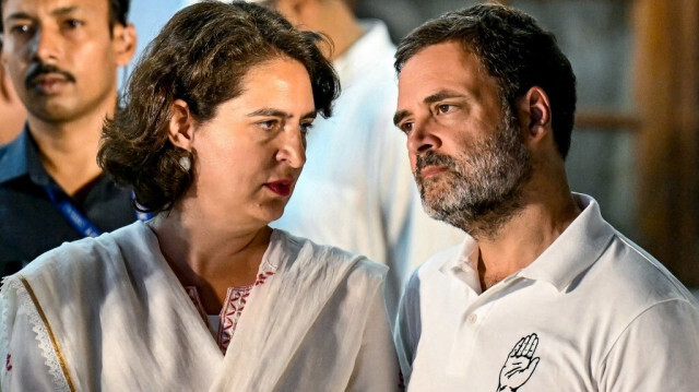 Les dirigeants du parti du Congrès national indien (INC) Rahul Gandhi parle à sa sœur Priyanka Gandhi Vadra pendant un discours du président du parti Mallikarjun Kharge (non photographié), après une réunion du bloc de l'alliance de l'opposition Indian National Developmental Inclusive Alliance (INDIA) à New Delhi le 5 juin 2024, le lendemain des résultats du vote pour les élections générales de l'Inde.