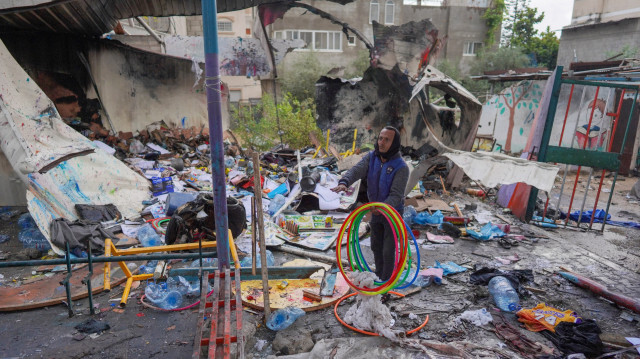 Un Palestinien récupère des objets dans les débris d'un conteneur dans une école de l'UNRWA utilisée pour abriter des personnes déplacées, après qu'elle ait été touchée par un bombardement israélien à Nusseirat, dans le centre de la bande de Gaza, le 6 mai 2024, dans le cadre du conflit actuel entre Israël et le mouvement palestinien Hamas.