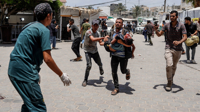 Un infirmier attend qu'un homme portant une fille blessée se précipite à l'hôpital des Martyrs d'al-Aqsa à Deir al-Balah, dans le centre de la bande de Gaza, après le bombardement israélien d'un appartement résidentiel à Deir al-Balah et d'une zone d'al-Maghazi, le 8 juin 2024, dans le cadre du conflit actuel entre Israël et le groupe militant palestinien Hamas.