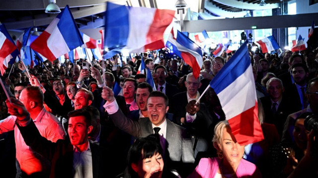 Des militants célèbrent l'annonce des résultats du vote lors d'un rassemblement du parti d'extrême droite français Rassemblement National (RN) le dernier jour de l'élection du Parlement européen, au Pavillon Chesnaie du Roy à Paris, le 9 juin 2024.