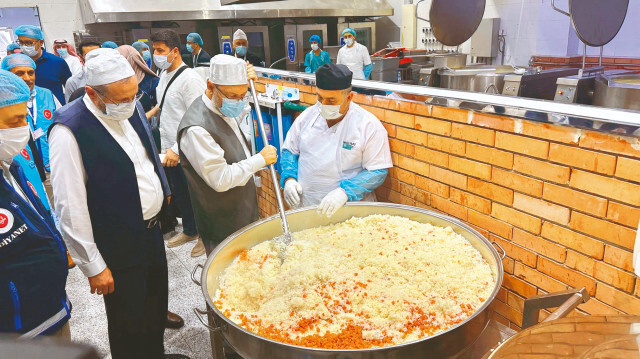 Erbaş, kazanın başına geçerek hacılar için hazırlanan pilavın yapımına yardım etti.