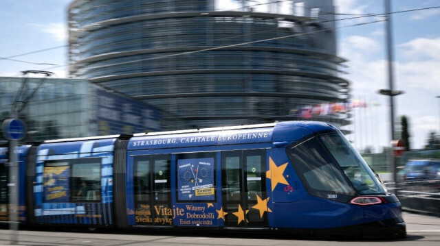 Cette photographie montre un tramway recouvert du thème des élections européennes passant devant le bâtiment du Parlement européen à Strasbourg, dans l'est de la France, le 6 juin 2024.